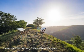 Aussichtspunkt mit Informationstafeln mit Blick auf Berge und ins Tal.