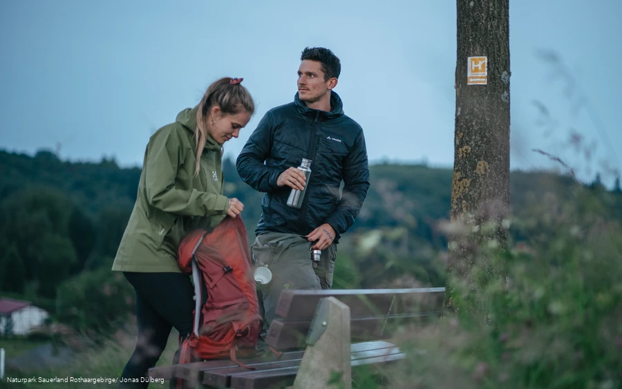 Ein Wanderpaar bereitet sich am Sauerland-Höhenflug nach einer Pause auf die Wanderung vor.