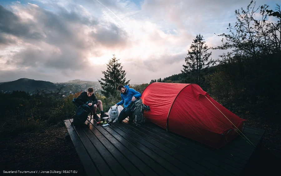 Zwei Männer richten sich auf einem Trekkingplatz ein