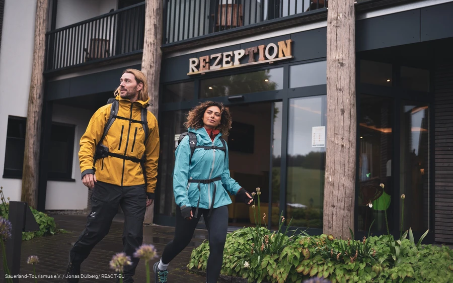 Zwei Wanderer starten ihre Wanderung am Hotel vor der Rezeption
