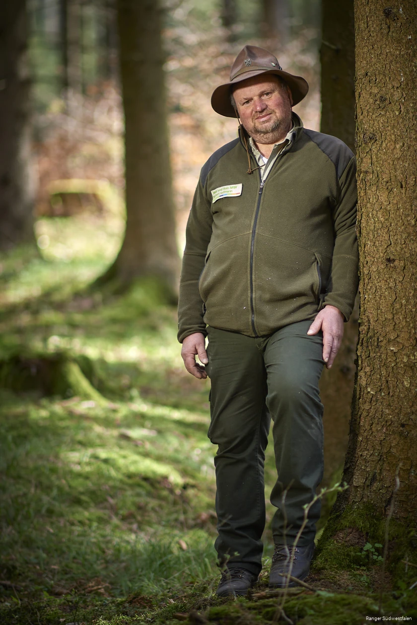 Ein Ranger steht im Wald.